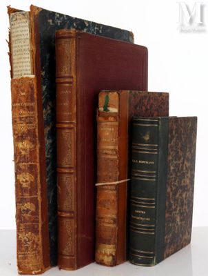 several old books are stacked on top of each other on a table