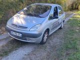 La voiture est garée sur le bord de la route, près des arbres.