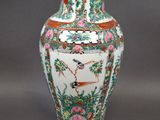 a vase with a bird on it sitting on a table