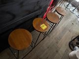 four stools that are sitting in front of a piano