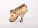 an image of a pair of gold shoes on a white surface