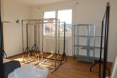 an image of a room with a lot of clothes on a rack