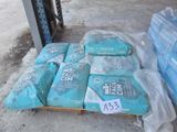 several bags of cement sit on a pallet in front of a pallet