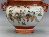 a vase with a painting on it sitting on a table