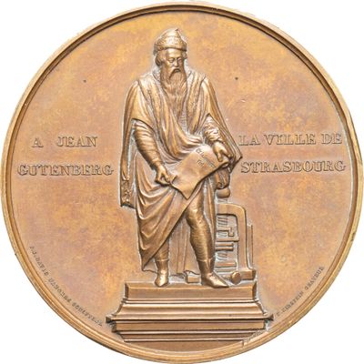 médaille de bronze représentant un homme assis sur une chaise, un livre sur les genoux