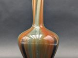 a vase that is sitting on a table in front of a gray background