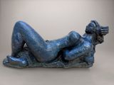 sculpture représentant une femme allongée sur un rocher, les jambes croisées