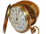 a gold pocket watch with a chain hanging from it ' s side