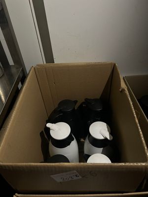 une boîte en carton posée par terre, contenant deux tasses