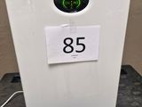 a white refrigerator sitting on a table with a sign on it