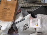 a shopping cart filled with bags of clothing and a box of pillows