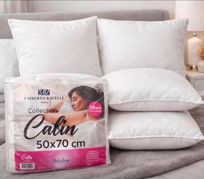 deux oreillers sur un lit, avec un oreiller posé dessus