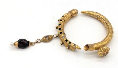 bracelet en or avec des perles noires et une perle noire sur fond blanc