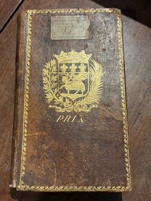 un vieux livre posé sur une table en bois, sur une table