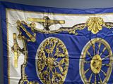 une image représentant une écharpe bleue et dorée sur laquelle figure une horloge