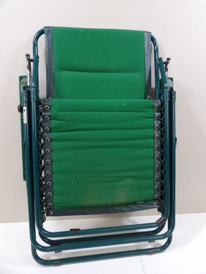 une chaise de jardin verte posée sur une table blanche