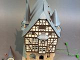 a small doll house with a clock on the front of it