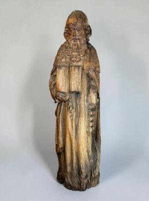 an old wooden statue of a man holding a book