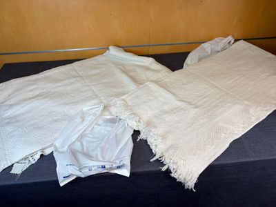 deux morceaux de tissu blanc posés sur une table noire