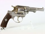 un vieux revolver avec une poignée en bois sur une surface blanche