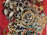 a red bag filled with lots of jewelry on a table