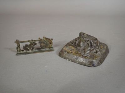 une petite statue représentant un homme à moto, à côté d'une autre petite statue représentant un homme à moto
