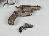 a small gun and a small revolver on a table