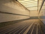 an image of a long empty room with wood flooring