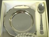 a silver plate in a box with a spoon and a spoon rest