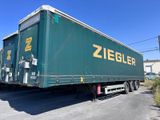 une semi-remorque verte garée sur le bord de la route