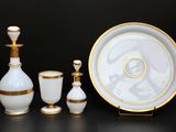 trois objets en verre blanc et doré posés sur une table