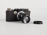 a black camera with a black lens on a white surface