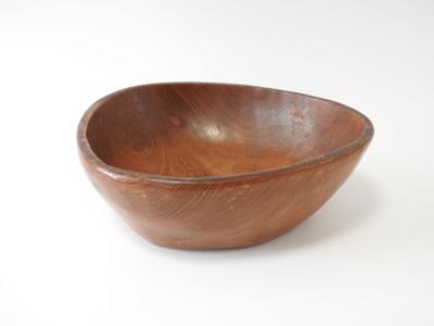 un bol en bois posé sur une surface blanche