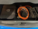 the trunk of a blue car with electronics in the trunk