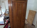 a tall wooden cabinet in the middle of a room