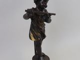 statue of a boy playing the flute with a flower on a lamp