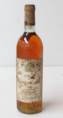 an old bottle of wine sitting on top of a white table