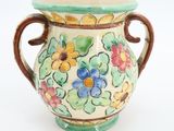 a vase with flowers painted on it on a white surface