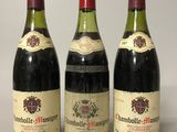 trois bouteilles de vin sont alignées sur une surface blanche