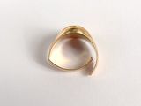 an image of a gold ring sitting on top of a white surface