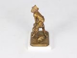 bronze figurine of a boy with a baseball bat on a base