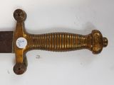 a gold colored sword with a black handle on a white surface