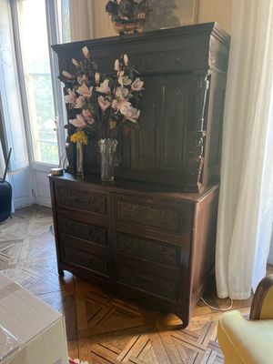 une commode sur laquelle sont posées des fleurs, dans un salon