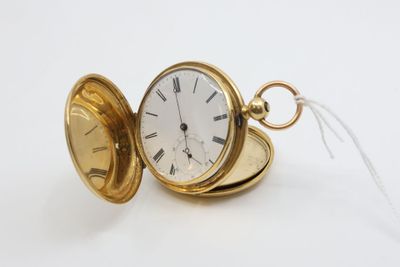 a gold pocket watch with a chain on a white surface