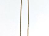 un long collier en or avec une chaîne sur fond blanc