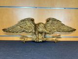 un gros plan d'un aigle royal tenant une flèche, posé sur une table