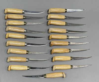 six couteaux sont alignés en rang sur une surface grise