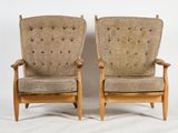 pair of mid - century danish lounge chairs with upholstered cushions