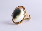 une image représentant une bague en or sertie d'une pierre noire et blanche