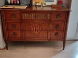 a dresser with a mirror on top of it in a living room